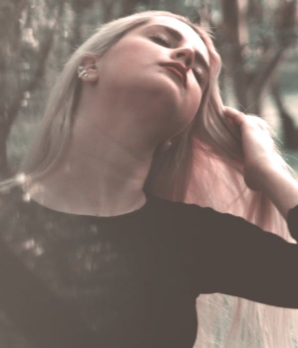 Person stretching outdoors in a park with soft morning light.